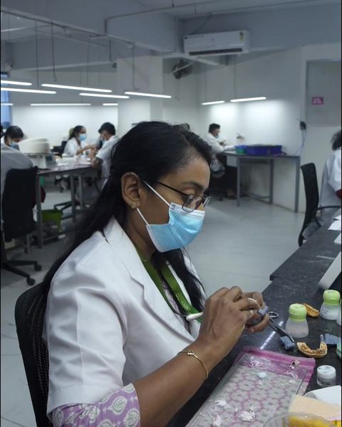 A ceramist building up porcelain on crowns in the ceramic department