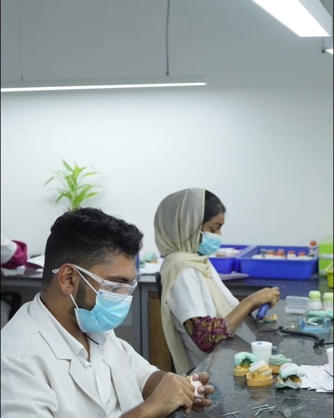 Two technicians working side by side at the ceramic benches